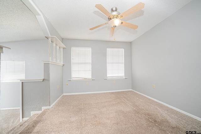 spare room with a textured ceiling, ceiling fan, and carpet floors