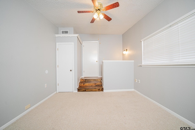 unfurnished room featuring ceiling fan, a textured ceiling, and carpet flooring