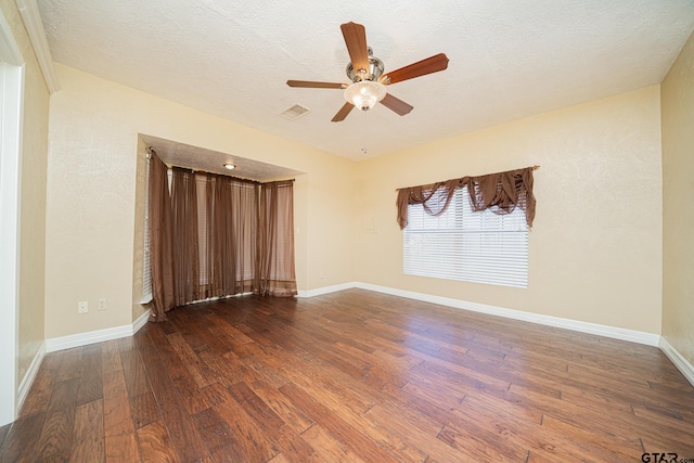 spare room with a textured ceiling, ceiling fan, and dark hardwood / wood-style floors