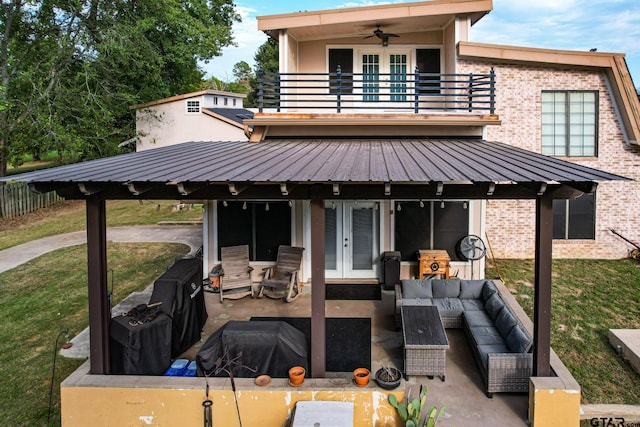 rear view of property featuring a patio area, an outdoor hangout area, a balcony, and a yard