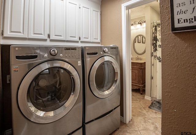 laundry area with washer and clothes dryer, light tile patterned floors, cabinets, and sink