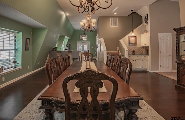 dining area featuring a notable chandelier, dark hardwood / wood-style floors, and a towering ceiling