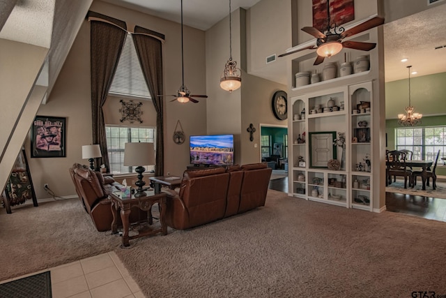 living room featuring a textured ceiling, a wealth of natural light, light colored carpet, and a high ceiling