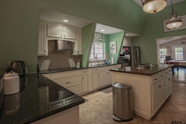 kitchen with a wealth of natural light, white cabinetry, stainless steel appliances, and extractor fan