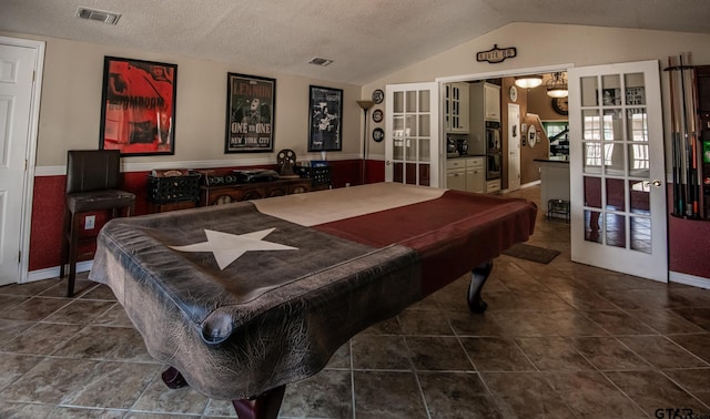 game room featuring french doors, a textured ceiling, vaulted ceiling, and pool table