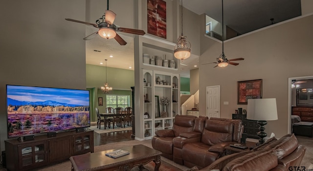 living room featuring a towering ceiling and ceiling fan with notable chandelier