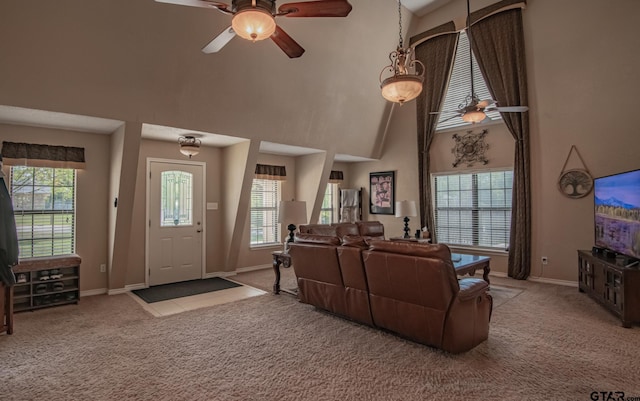 living room with plenty of natural light, ceiling fan, light carpet, and high vaulted ceiling