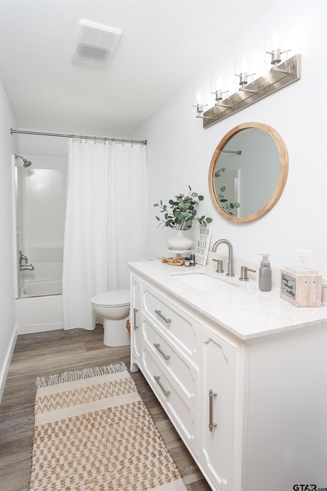 306 Lake Dr, Mount Vernon, TX 75457 - bathroom with toilet, vanity, wood finished floors, and shower / bath combo with shower curtain