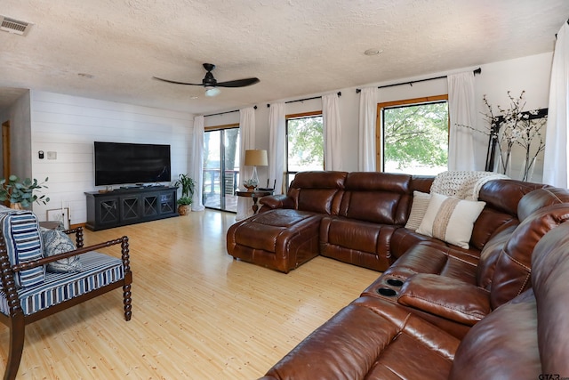 306 Lake Dr, Mount Vernon, TX 75457 - living area featuring wood finished floors, ceiling fan, a textured ceiling, and wooden walls