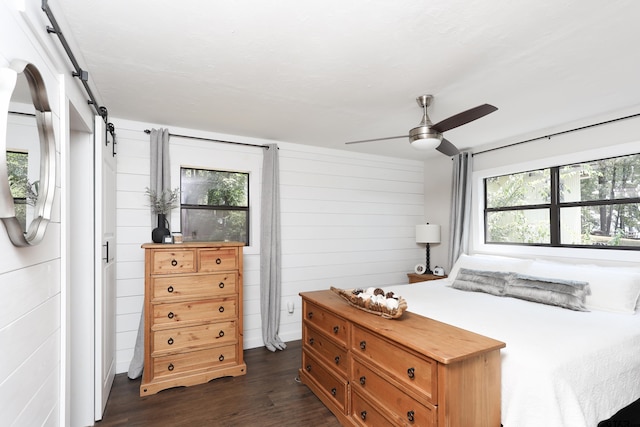 306 Lake Dr, Mount Vernon, TX 75457 - bedroom featuring a barn door, dark wood-style flooring, and ceiling fan