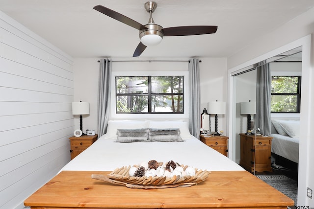 306 Lake Dr, Mount Vernon, TX 75457 - bedroom featuring wood walls and ceiling fan