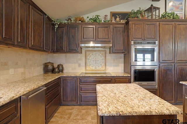 kitchen featuring light stone countertops, black electric stovetop, stainless steel double oven, vaulted ceiling, and exhaust hood