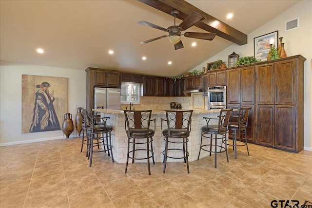 kitchen featuring a breakfast bar, a spacious island, ceiling fan, and vaulted ceiling with beams