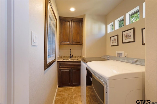 laundry area with separate washer and dryer, sink, cabinets, and light tile patterned flooring