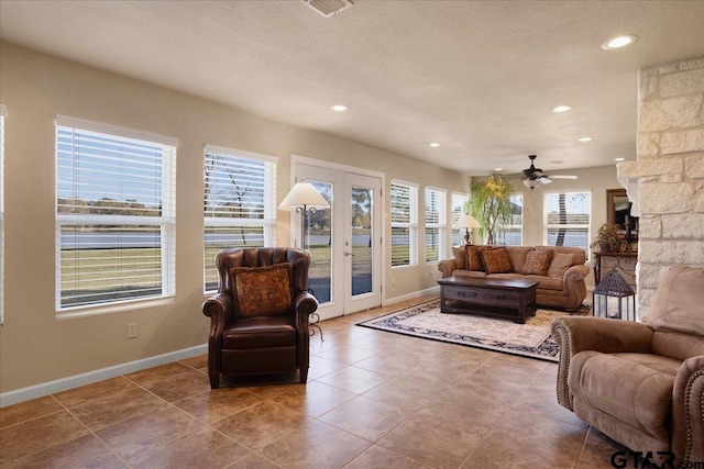 interior space featuring a fireplace, ceiling fan, and french doors