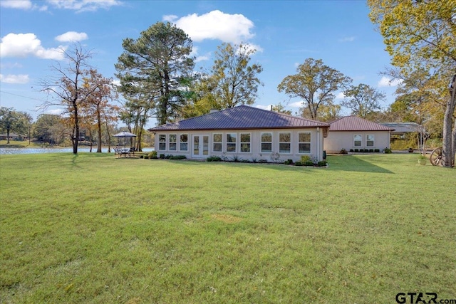 back of property featuring a yard and a water view