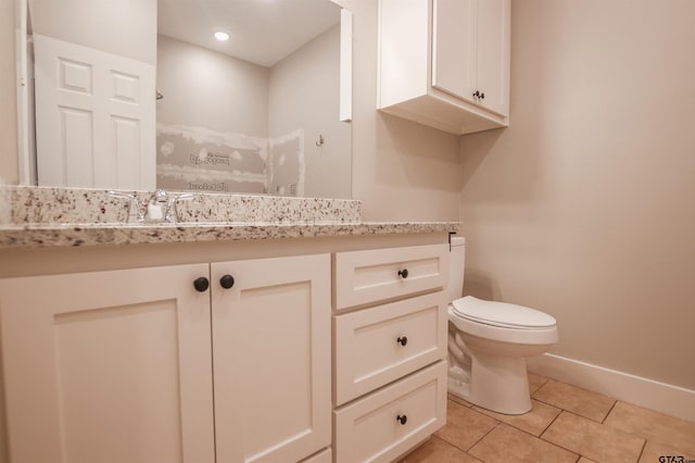 bathroom with toilet, tile patterned floors, vanity, and baseboards