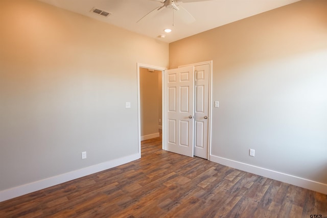 empty room featuring visible vents, ceiling fan, baseboards, and dark wood finished floors