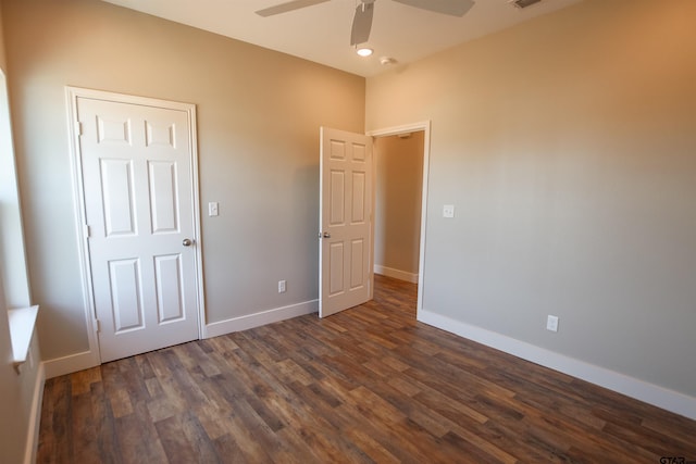 unfurnished bedroom featuring dark wood-type flooring, baseboards, a ceiling fan, and visible vents