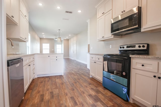 kitchen featuring a peninsula, visible vents, dark wood finished floors, stainless steel appliances, and a sink