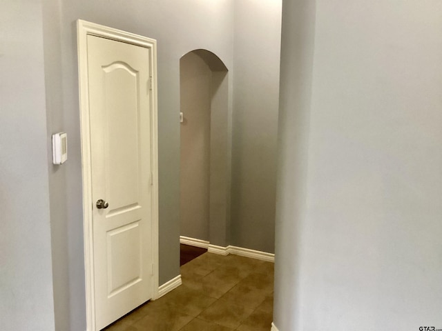 hall with tile patterned floors