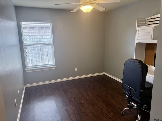 unfurnished office with dark hardwood / wood-style floors and ceiling fan