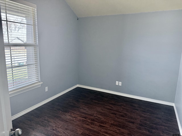 spare room with lofted ceiling and dark hardwood / wood-style floors