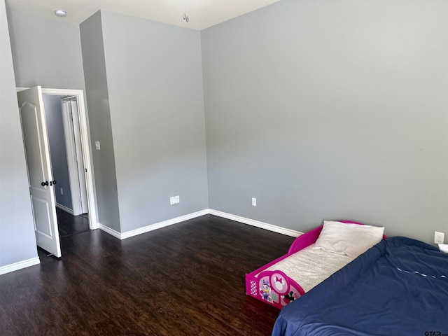 bedroom with dark hardwood / wood-style floors