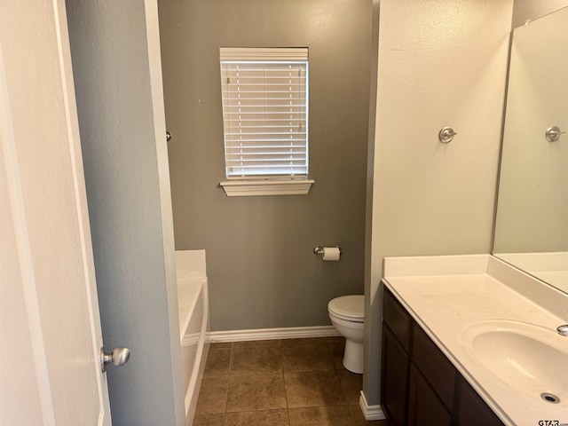 bathroom featuring tile patterned floors, toilet, vanity, and a washtub