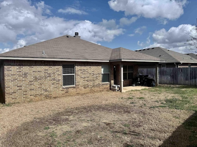 rear view of house featuring a lawn