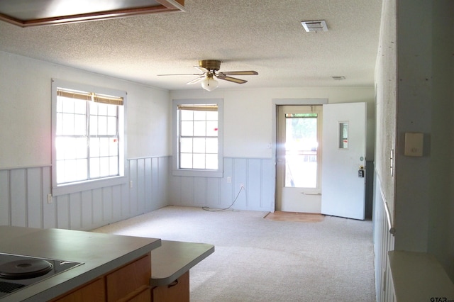 411 N College St, Lindale, TX 75771 - dining room with wainscoting, ceiling fan, light carpet, and a textured ceiling
