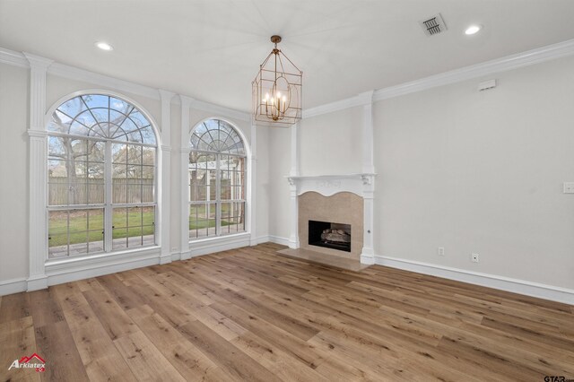 6309 Gleneagles, Tyler, TX 75703 - unfurnished living room with visible vents, a chandelier, plenty of natural light, ornamental molding, and wood finished floors