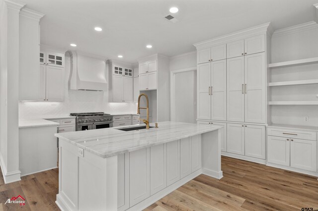 6309 Gleneagles, Tyler, TX 75703 - kitchen with white cabinets, visible vents, custom exhaust hood, a sink, and range with two ovens