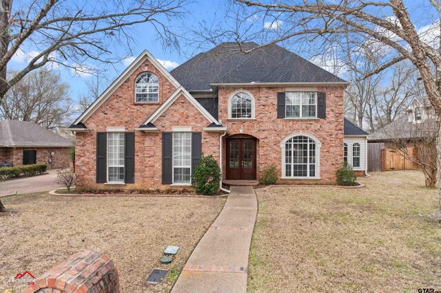 6309 Gleneagles, Tyler, TX 75703 - view of front of house featuring fence, french doors, a front lawn, brick siding, and a shingled roof