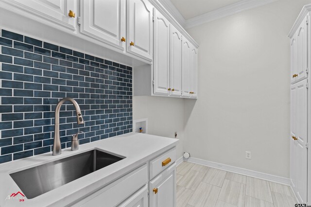 6309 Gleneagles, Tyler, TX 75703 - laundry area with ornamental molding, hookup for a washing machine, baseboards, a sink, and cabinet space