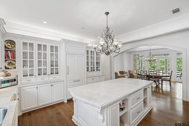1920 Stonegate Blvd, Tyler, TX 75703 - kitchen featuring visible vents, arched walkways, white cabinetry, open shelves, and an inviting chandelier