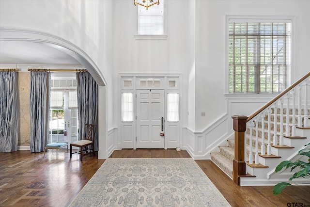 1920 Stonegate Blvd, Tyler, TX 75703 - foyer with arched walkways, dark wood-style flooring, a decorative wall, and stairway