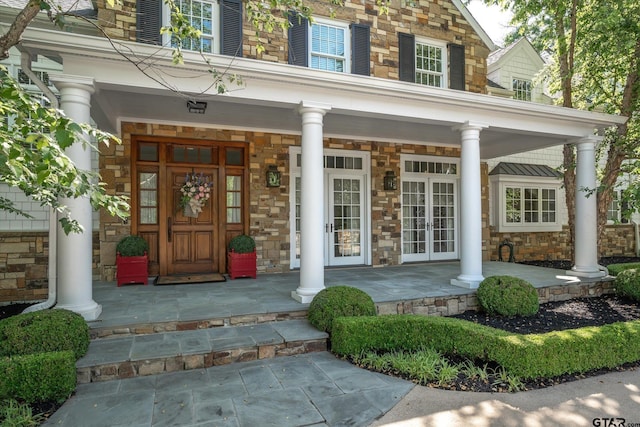 1920 Stonegate Blvd, Tyler, TX 75703 - view of exterior entry featuring a porch, stone siding, and french doors