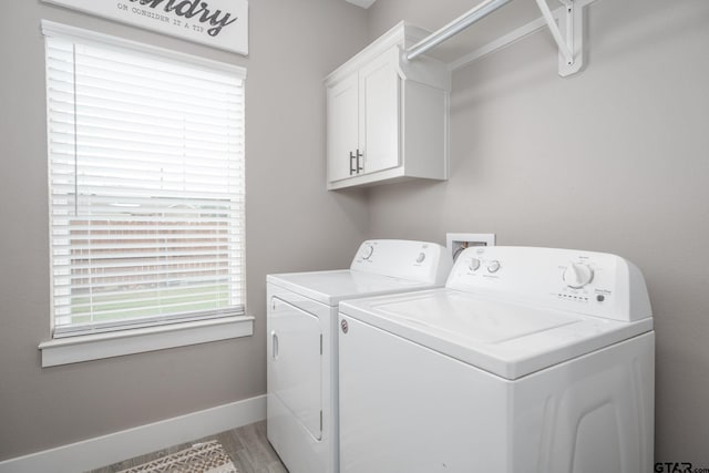 15365 Spring Oaks Dr, Lindale, TX 75771 - laundry area featuring washing machine and dryer, cabinet space, plenty of natural light, and light wood-type flooring