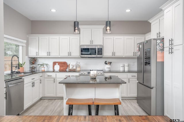 15365 Spring Oaks Dr, Lindale, TX 75771 - kitchen featuring stainless steel appliances, light wood-style floors, white cabinets, and recessed lighting