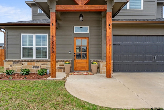 15365 Spring Oaks Dr, Lindale, TX 75771 - view of exterior entry with driveway, an attached garage, stone siding, and roof with shingles