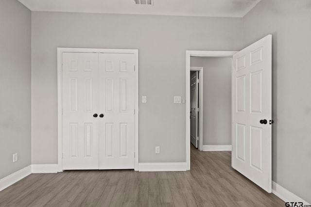 unfurnished bedroom featuring a closet and light hardwood / wood-style flooring