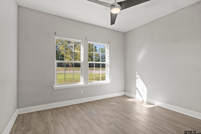 empty room with ceiling fan, a healthy amount of sunlight, and light hardwood / wood-style flooring