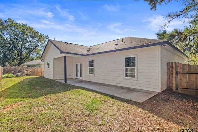 rear view of house with french doors, a lawn, and a patio