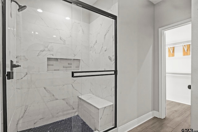 bathroom with hardwood / wood-style flooring and a shower with shower door