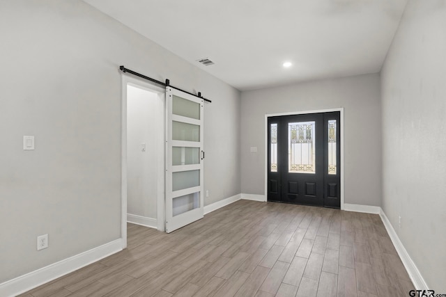 foyer featuring light hardwood / wood-style flooring and a barn door