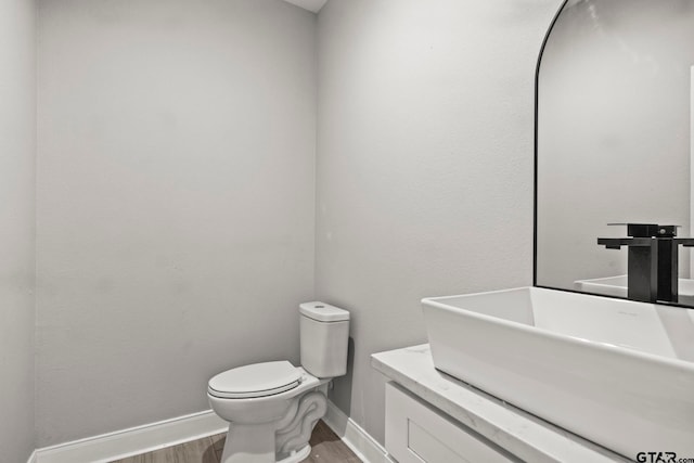 bathroom featuring hardwood / wood-style floors, vanity, and toilet