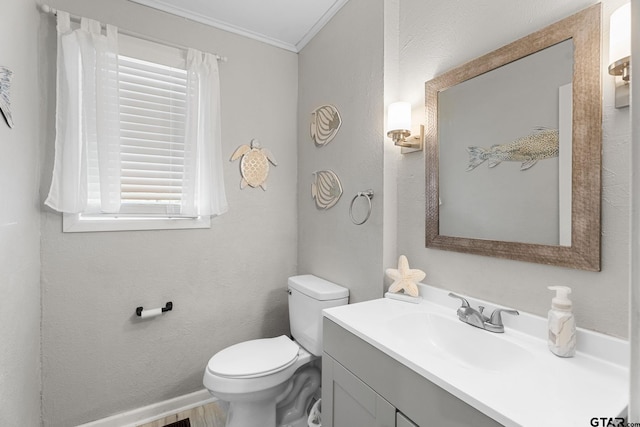 bathroom featuring vanity, toilet, and crown molding