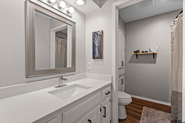 bathroom with hardwood / wood-style floors, vanity, and toilet