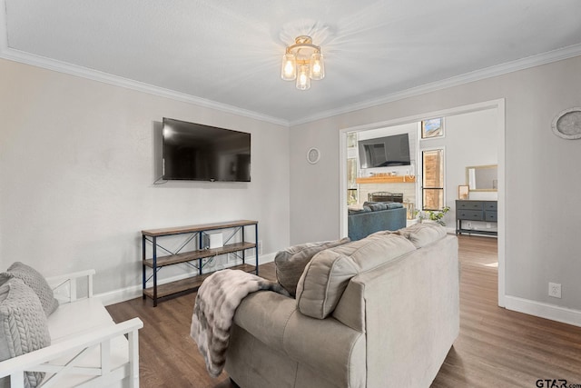 living room with dark wood-type flooring, a notable chandelier, and ornamental molding